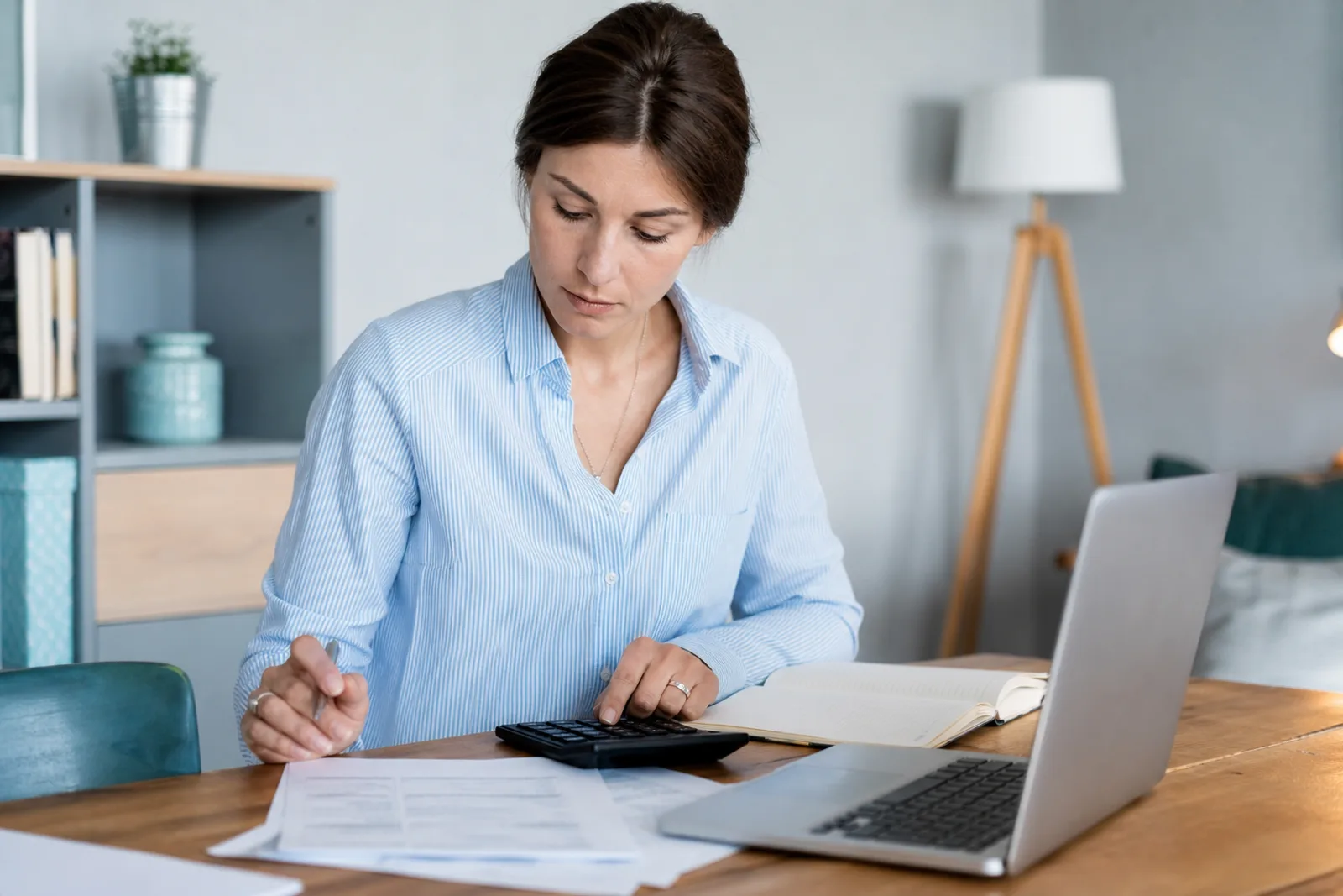 Propriétaire consultant des documents et factures de travaux pour calculer la fiscalité de son bien locatif.