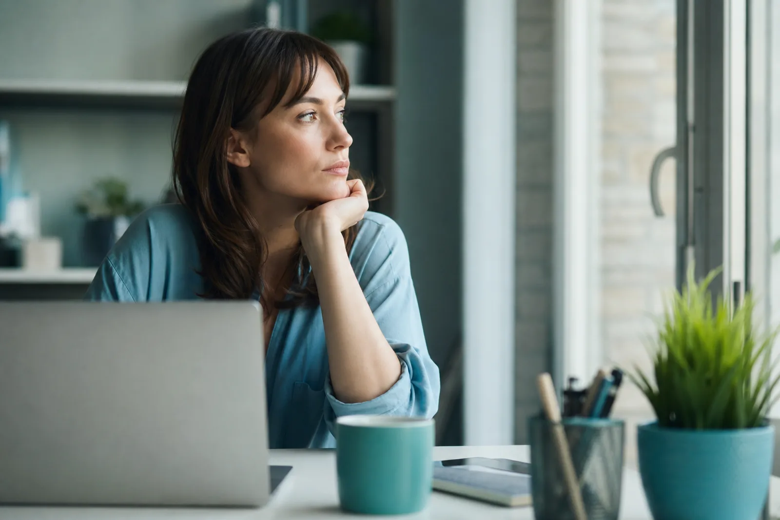 Une personne consulte des documents de reconversion professionnelle et de recherche de formation sur un bureau lumineux.